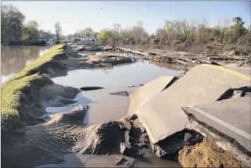  ?? Neil Blake / The Grand Rapids Press via AP ?? A section of Saginaw Road in Sanford, Mich., washed away due to dam failures at Wixom Lake.