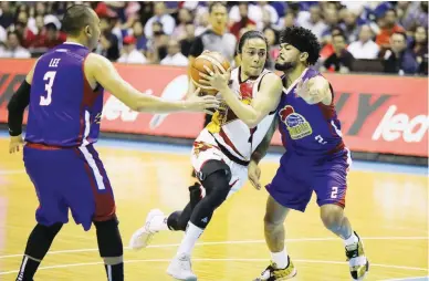  ??  ?? San Miguel Beer’s Terrence Romeo, center, tries to drive past Magnolia’s Paul Lee and Justin Melton, 2, during Game 2 of the PBA Philippine Cup Finals Friday at the Smart Araneta Coliseum. The Beermen won, 108-101, to tie the series at 1-1. (PBA Images)