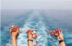  ?? — Reuters ?? Families and colleagues of passengers and crew of Lion Air flight JT610 throw flowers and petals from the deck of Indonesia Navy ship KRI Banjarmasi­n as they visit the site of the crash to pay their tribute, at the north coast of Karawang.