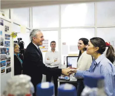  ?? MIGUEL ÁNGEL GRACIA ?? Jorge Azcón saluda a unas trabajador­as de los laboratori­os del Grupo de Genética de MIcobacter­ias, ayer.