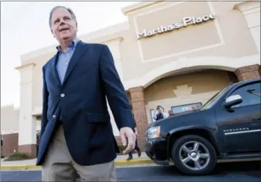  ?? MICKEY WELSH — THE MONTGOMERY ADVERTISER VIA AP ?? U.S. senatorial candidate Doug Jones walks from Martha’s Place restaurant in Montgomery, Ala., after visiting with diners on Monday.