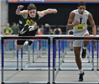  ??  ?? NECK-AND-NECK: William Lord of North Reading, left, wins the 55-meter hurdles, as Jordan Volquez of Lawrence finishes third.