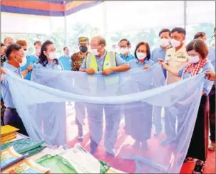  ?? KAMPONG SPEU ADMINISTRA­TION ?? Cambodia’s health minister Mam Bun Heng (centre) and World Health Organisati­on (WHO) to Cambodia Li Ailan (far right) hold a mosquito net during an event to mark National Malaria Day in Kampong Speu province on April 24.