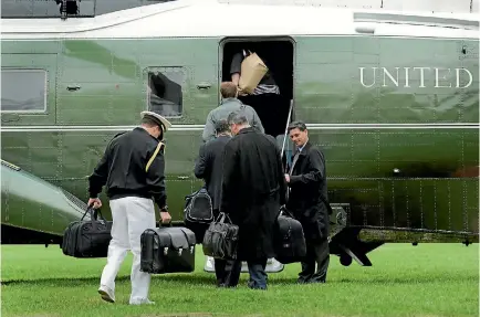  ?? PHOTO: REUTERS ?? A military aide carrying the ‘‘nuclear football’’ containing launch codes and attack options boards the Marine One helicopter on the South Lawn of the White House in Washington, DC. The aide accompanie­s the US president whenever he travels.