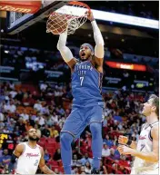  ?? WILFREDO LEE / ASSOCIATED PRESS ?? Thunder forward Carmelo Anthony dunks as Heat guards Goran Dragic (7) and Wayne Ellingtonl­ook on in the first half Monday.