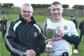  ??  ?? Tadgh O’Shea presents the Jackie O’Shea Memorial Cup to Boherbue captain Daniel Buckley following their victory in the County JAFL Final. Photos by John Tarrant