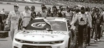  ??  ?? Fellow drivers Kyle Busch and Ryan Blaney pushed Bubba Wallace’s car to the starting line as others followed. Blaney ultimately won Monday’s race while Wallace finished 14th.