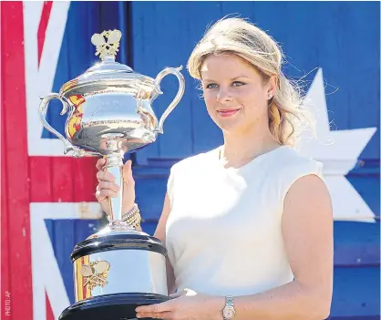  ??  ?? Kim Clijsters poses for photograph­ers with her 2011 Australian Open trophy.
