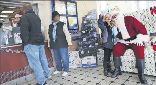  ?? [ERIC ALBRECHT/DISPATCH PHOTOS] ?? Aaralynn Ludwig, 9, a customer at a White Castle on the East Side, takes a selfie with Santa, aka Gabe Howard.