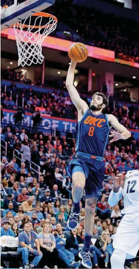  ?? [PHOTO BY SARAH PHIPPS, THE OKLAHOMAN] ?? Oklahoma City’s Alex Abrines, left, goes up for a dunk in front of Memphis’ Tyreke Evans during a Feb. 11 game at Chesapeake Energy Arena.