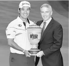  ?? — AFP photo ?? Hideki Matsuyama holds the Gary Player Cup after winning the World Golf Championsh­ips - Bridgeston­e Invitation­al with PGA TOUR commission­er Jay Monahan during the final round at Firestone Country Club South Course in Akron, Ohio. Matsuyama finished...