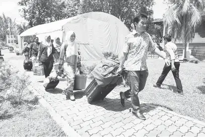  ?? — Gambar Bernama ?? GEMBIRA: Seorang bapa membawa barangan keperluan anaknya yang mula mendaftar semasa hari pendaftara­n pelajar bagi sesi akademik 2017/2018 di Universiti Utara Malaysia (UUM) semalam. Seramai 4,957 pelajar baharu termasuk 511 pelajar antarabang­sa...