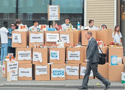  ?? Picture: AP. ?? Anti-Brexit activists protest as they deliver a pile of medical supplies in cardboard boxes to the Department of Health and Social Care in London.