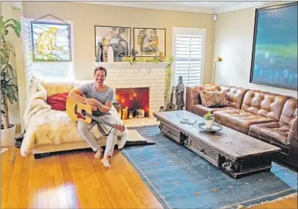  ?? Photograph­s by Jesse Goddard For The Times ?? A MIX of coziness and hidden high tech, this inviting space is what actor Paul Greene calls the “heart of the home.” He shares the Craftsman-style house with his fiancee and his teenage son.