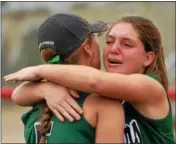  ?? STEVE HARE — THE NEWS‑ HERALD ?? Lake Catholic’s Kennedy Solymosi, right, embraces Nicole Bush after Akron Hoban defeated the Cougars in a Division II regional final on May 27 in Akron.