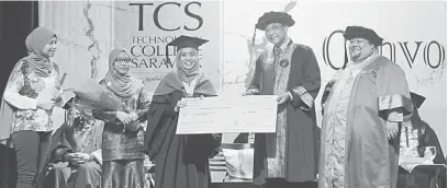  ??  ?? TAHNIAH: Karim menyampaik­an anugerah kepada graduan ijazah terbaik, Nur Shakirin Mohamad pada Konvokesye­n Ke-14 TCS di Kuching semalam. Turut kelihatan Azri (kanan).