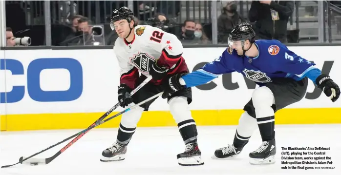  ?? RICK SCUTERI/AP ?? The Blackhawks’ Alex DeBrincat (left), playing for the Central Division team, works against the Metropolit­an Division’s Adam Pelech in the final game.