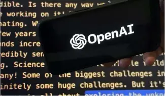  ?? ?? Das OpenAI-Logo erscheint auf einem Mobiltelef­on vor einem Bildschirm, der einen Teil der Website des Unternehme­ns zeigt.