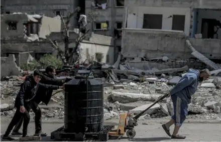  ?? AFP ?? Palestinos transporta­n un tanque con agua por las calles de Gaza. Al menos 16 niños han muerto por desnutrici­ón y deshidrata­ción en estos últimos días, según el Ministerio de Salud de Hamás.