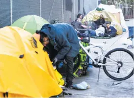  ??  ?? Top: A homeless encampment beneath an overpass on Fifth Street. Above: Occupants at a camp on Duboce Avenue, a few blocks from San Francisco’s newest Navigation Center homeless shelter on South Van Ness Avenue.