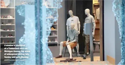  ?? SCOTT OLSON/GETTY IMAGES ?? A window is shattered at a Timberland store on Michigan Avenue, the scene of widespread looting late Sunday and early Monday.