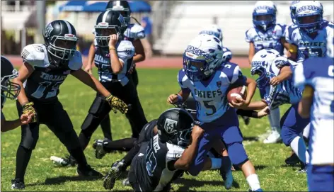  ??  ?? El Centro Trojans’ Christophe­r Nunez (middles) drags down a ball carrier during a home American Youth Football game against the Lake Havasu Chiefs on Saturday afternoon in El Centro.