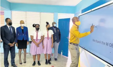  ?? CONTRIBUTE­D ?? Devon Ince (right), vice-principal for operations and human resource, Pembrooke Hall High School, teaches with the new Huawei Jamaica IdeaHub interactiv­e donated to the school located in St Andrew on Thursday. Looking on are (from left): Dr Nigel Clarke, member of parliament for St Andrew North Western and minister of finance and the public service; Fayval Williams, minister of education, youth and informatio­n; students Nicola Leslie and Juwonna Mitchell; and principal, Claude Ellis.