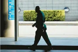  ?? AMY BETH BENNETT /SOUTH FLORIDA SUN SENTINEL ?? A Broward Sheriff’s deputy walks from Terminal 2 at Fort Lauderdale-Hollywood Internatio­nal Airport on Friday. A county audit that examined the Broward Sheriff’s Office’s service at the airport found it has the highest budgeted cost of law enforcemen­t services per passenger boarding a plane at an airport.