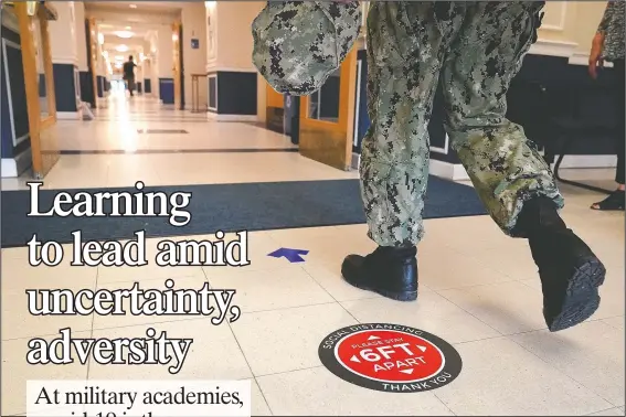  ?? (AP/Julio Cortez) ?? A social distancing sign is seen on the floor as a midshipman walks to class at Luce Hall on Aug. 24 at the Naval Academy in Annapolis, Md.