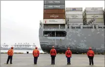  ?? CHINATOPIX ?? Workers watch a container ship arrive Tuesday at a port in Qingdao in east China’s Shandong province. China cut tariffs Thursday on $75 billion of U.S. imports, including auto parts, in response to American reductions as part of their truce in a trade war.