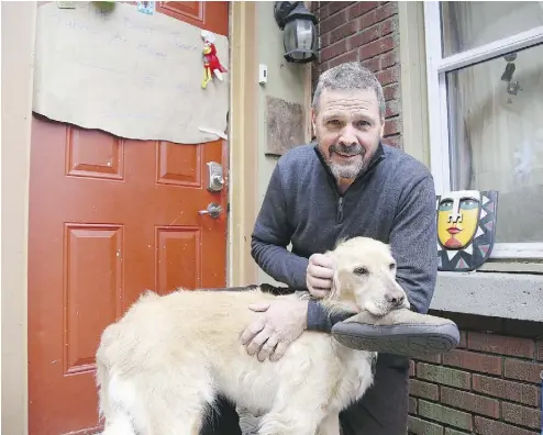  ?? GINO DONATO/SUDBURY STAR/POSTMEDIA NETWORK ?? Dave Battaino stands outside his home in Sudbury, Ont., on Wednesday with his daughter’s dog Rosseau. Battaino had returned home on Halloween night to find a burglar in his basement. He helped chase down the suspect.