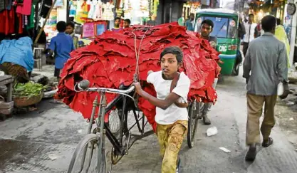  ?? —AP ?? A Bangladesh­i boy pulls a rickshaw loaded with strips of leather at the highly polluted Hazaribagh tannery area in Dhaka, Bangladesh.