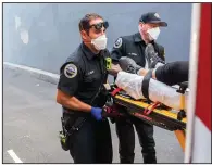  ?? (AP/Nathan Howard) ?? Paramedics Cody Miller (left) and Justin Jones respond to a heat-exposure call Saturday in Salem, Ore.