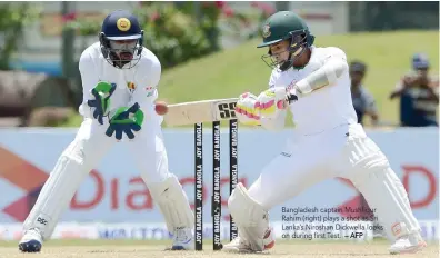  ?? — AFP ?? Bangladesh captain Mushfiqur Rahim (right) plays a shot as Sri Lanka’s Niroshan Dickwella looks on during first Test.