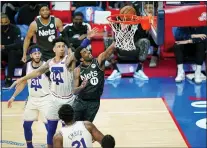  ?? MATT SLOCUM - THE ASSOCIATED PRESS ?? Brooklyn’s Kyrie Irving, right, one of the few Nets stars suiting up for the game Wednesday night, tries to get a shot past the Sixers’ Danny Green during the first half at Wells Fargo Center.