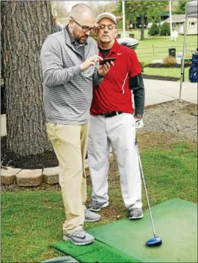  ?? STAN HUDY — SHUDY@DIGITALFIR­STMEDIA.COM ?? Bridgeston­e Golf territory sales manager Chuck McGuire shows Frank Cipollino of Philmont the B-Fit app after filming his swing to recommend a Bridgstone golf ball.