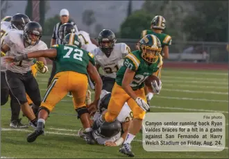  ?? File photo ?? Canyon senior running back Ryan Valdes braces for a hit in a game against San Fernando at Harry Welch Stadium on Friday, Aug. 24.