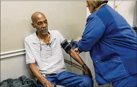  ??  ?? Neville gets his blood pressure checked by a nurse at the Central Health and Wellness Center.