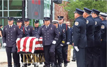  ?? CHRIS KOHLEY / MILWAUKEE JOURNAL SENTINEL ?? Members of the Sun Prairie Fire Department lead Capt. Cory Barr’s casket to the front entrance of Sun Prairie High School, where his funeral was held on Saturday. Barr died in an explosion Tuesday in downtown Sun Prairie. An estimated 700 people from other department­s attended. Among them were firefighte­rs from department­s in Chicago and Nebraska. See more photos at jsonline.com/news.