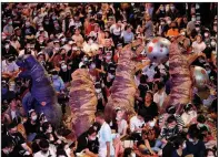  ?? (AP/Sakchai Lalit) ?? People in dinosaur costumes are surrounded by the crowd Saturday at a student rally in Bangkok. More photos at arkansason­line. com/1122bangko­k/.