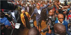  ??  ?? Kenya's President Uhuru Kenyatta high-fives with supporters after casting his vote in Tuesday's presidenti­al election, in which he was declared the winner.