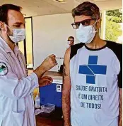  ??  ?? Brasileiro­s usam camisetas que homenageia­m o SUS, as vacinas e a ciência e criticam o presidente Jair Bolsonaro; até famosos aderiram à moda, como o cantor Leoni (ao centro)