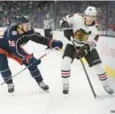  ?? JAY LAPRETE/AP ?? Blackhawks winger Patrick Kane, right, clears the puck past the Blue Jackets’ Jack Roslovic during the third period Saturday in Columbus, Ohio. The Hawks lost 4-1.