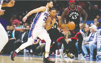  ?? BILL STREICHER/USA TODAY SPORTS ?? Philadelph­ia 76ers guard Ben Simmons attempts to knock the ball from Toronto Raptors guard Norman Powell during Sunday’s game, a 110-104 Philadelph­ia win on home court.