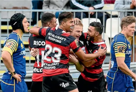  ??  ?? Team-mates congratula­te Johnny McNicholl after his try against Otago.