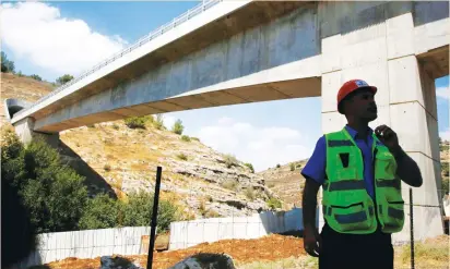  ??  ?? AN ISRAEL RAILWAYS employee surveys a bridge for the high-speed railway between Tel Aviv and Jerusalem.