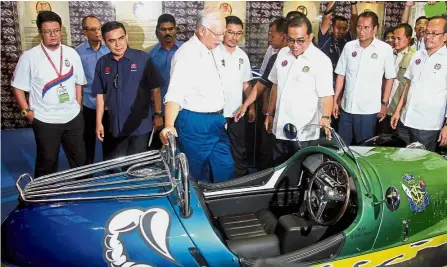  ?? — Bernama ?? Open top: Najib and Johor Menteri Besar Datuk Seri Mohamed Khaled Nordin (third from right) looking at a Morgan three-wheeled automobile used by the Johor Sultan during the Johor Mahkota Travel 2017 last month.