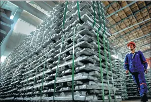  ?? LUO ZHIKEN / FOR CHINA DAILY ?? A worker walks past aluminum ingots at a factory of Chinalco in Baise in the Guangxi Zhuang autonomous region.