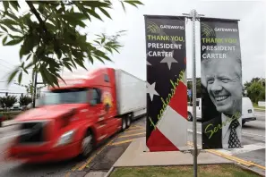  ?? The Associated Press ?? ■ Motorists pass a sign dedicated to former President Jimmy Carter along Jimmy Carter Boulevard on Tuesday in Norcross, Ga.