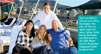  ??  ?? Voor van links is Tom se vrou, Nicci, hul dogter, Yasmin, en Tom, en agter staan hul seun, Dyllan. Hulle het by die Radisson Red-hotel in die V&amp;A Waterfront in Kaapstad uitgespan nadat hy gewen het.